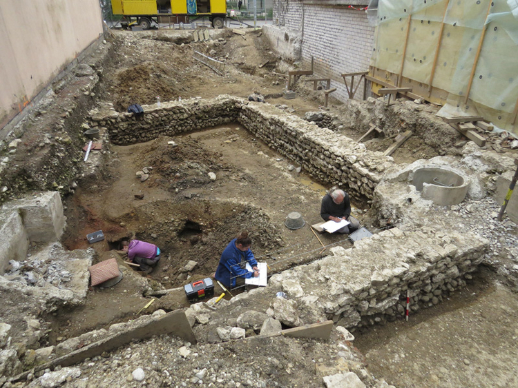 Grabungsbild mit Mauer und Mitarbeitenden
