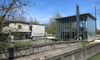 Zwei unterschiedliche Gebäude am Wasser. Rechts mit viel Glas. Links ein altes Gebäude.