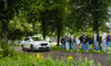 Jugendliche beobachten Bremsweg-Demonstration mit fahrendem Auto.