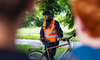 Polizist mit Velohelm erklärt Jugendlichen die Regeln im Strassenverkehr.