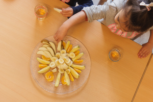 Kinder essen zum Znüni Früchte an einem Tisch