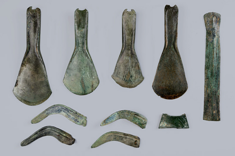 Vier Beile, vier Sicheln, ein Schwertfragment, ein Metallfragment