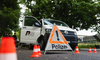 Polizeifahrzeug mit Warndreieck und Pylonen bei Verkehrssicherheitsaktion.