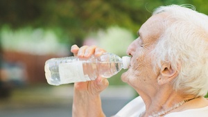 Alte Frau trinkt Wasser