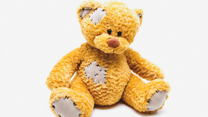 Gewalt und Schutz Bild eines geflickten Teddybärs.