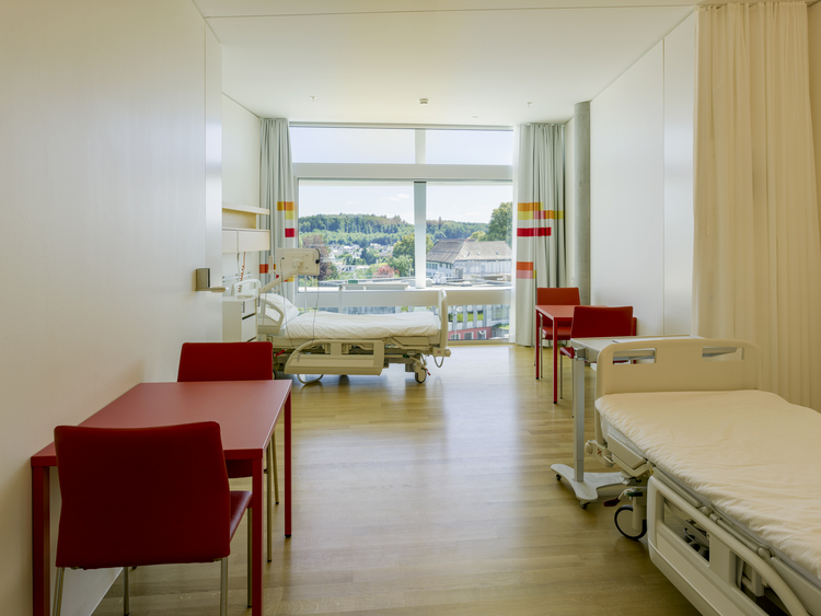 Ein Patientenzimmer im Neubau des Bürgerspitals Solothurn mit zwei Betten und zwei Tischen.