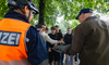 Jugendliche betrachten gemeinsam mit Polizei und Fachperson ein Plakat.