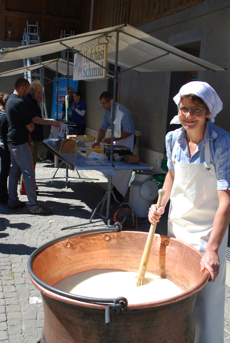 Wallierhoftag 2019 Frau auf Markt rührt mit Kelle in Topf bei Käseherstellung