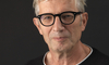 Maler Bruno Seitz posiert vor schwarzem Hintergrund.
