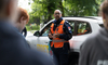 Polizist informiert Jugendliche zur Verkehrssicherheit vor Einsatzfahrzeug.