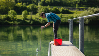 Simon Stüdeli nimmt hier Wasserprobe aus der Aare.