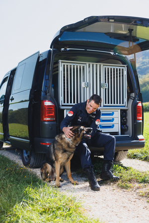 Ulrich Oppliger und sein Hund Jedi sitzen vor Dienstwagen