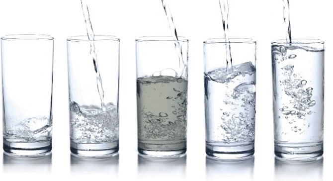 Fünf gefüllte Wassergläser. Eins davon mit verschmutztem Wasser