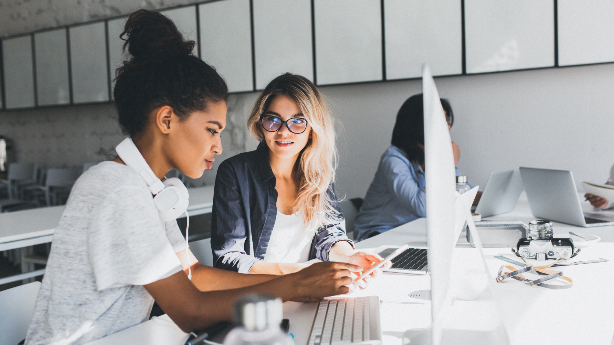 Ausländische Arbeitnehmerinnen an einem Büro-Arbeitsplatz