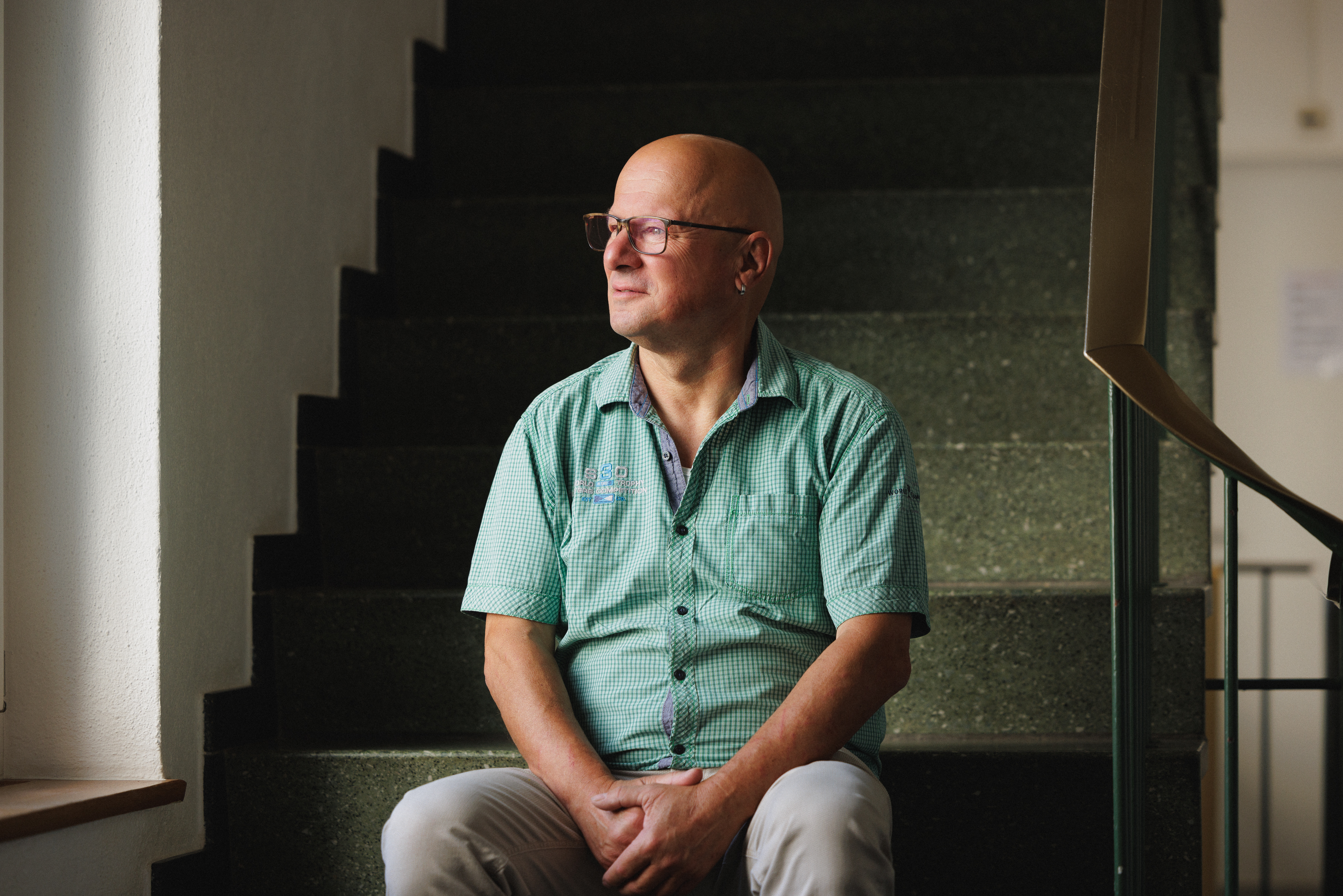 Harry Bloch sitzt auf der Treppe im Gang des Amts für Justizvollzug
