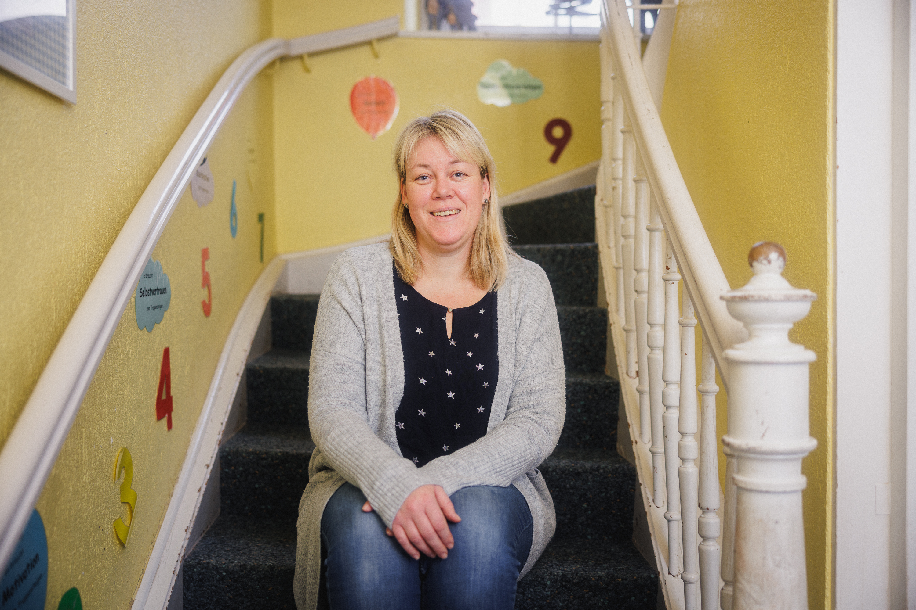 Krippenleiterin Anne Peter sitzt auf einer Treppe in der Sonnhalde