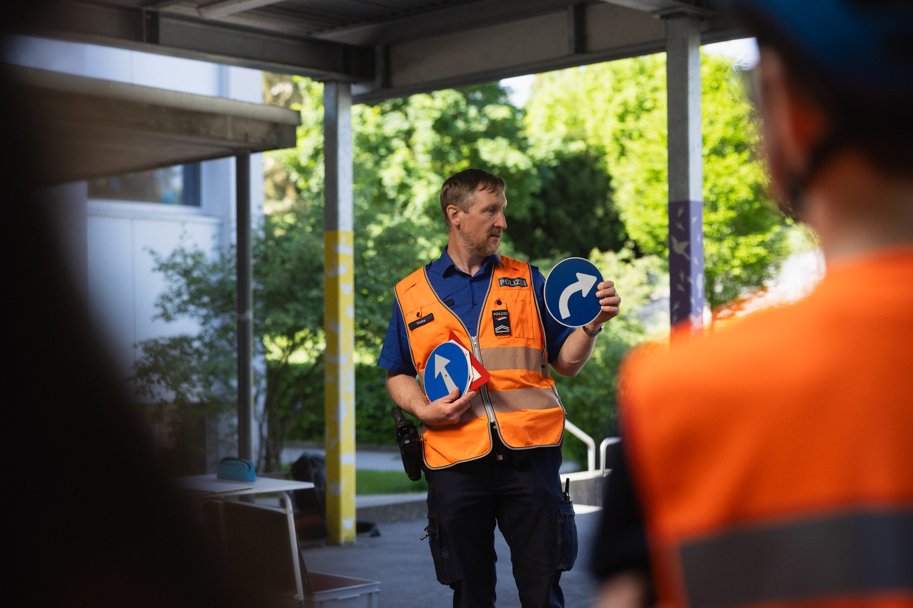 Verkehrsinstruktor Philipp Kissling erklärt einer Schulklasse die Verkehrszeichen