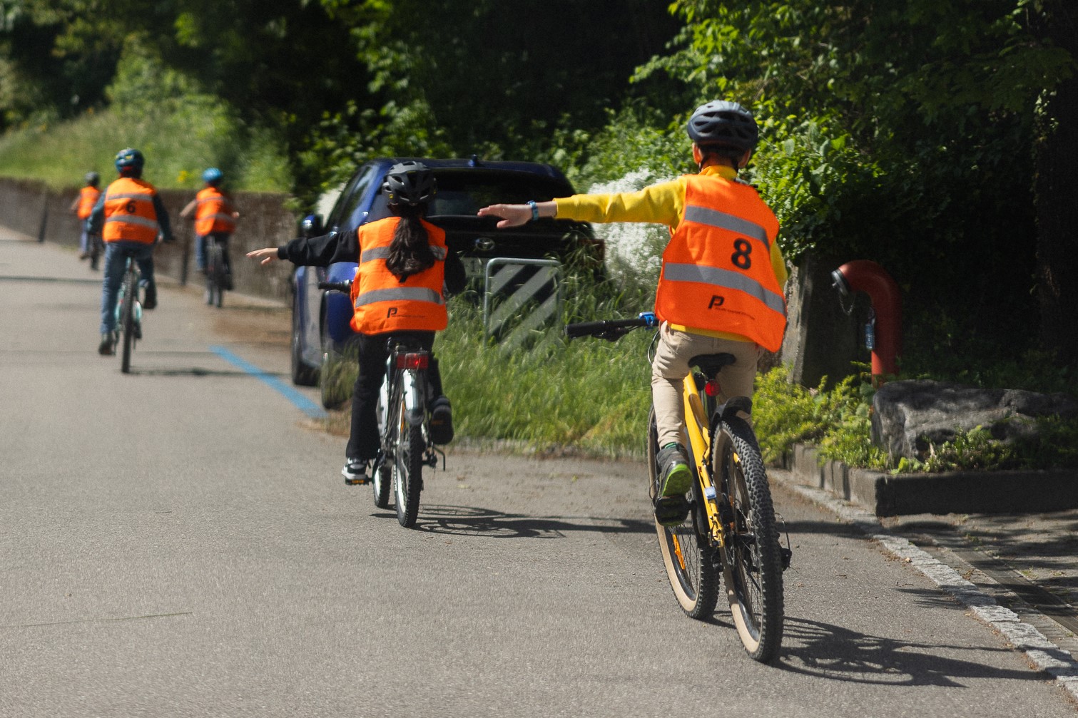 Kinder auf dem Velo absolvieren auf der Strasse die Veloprüfung