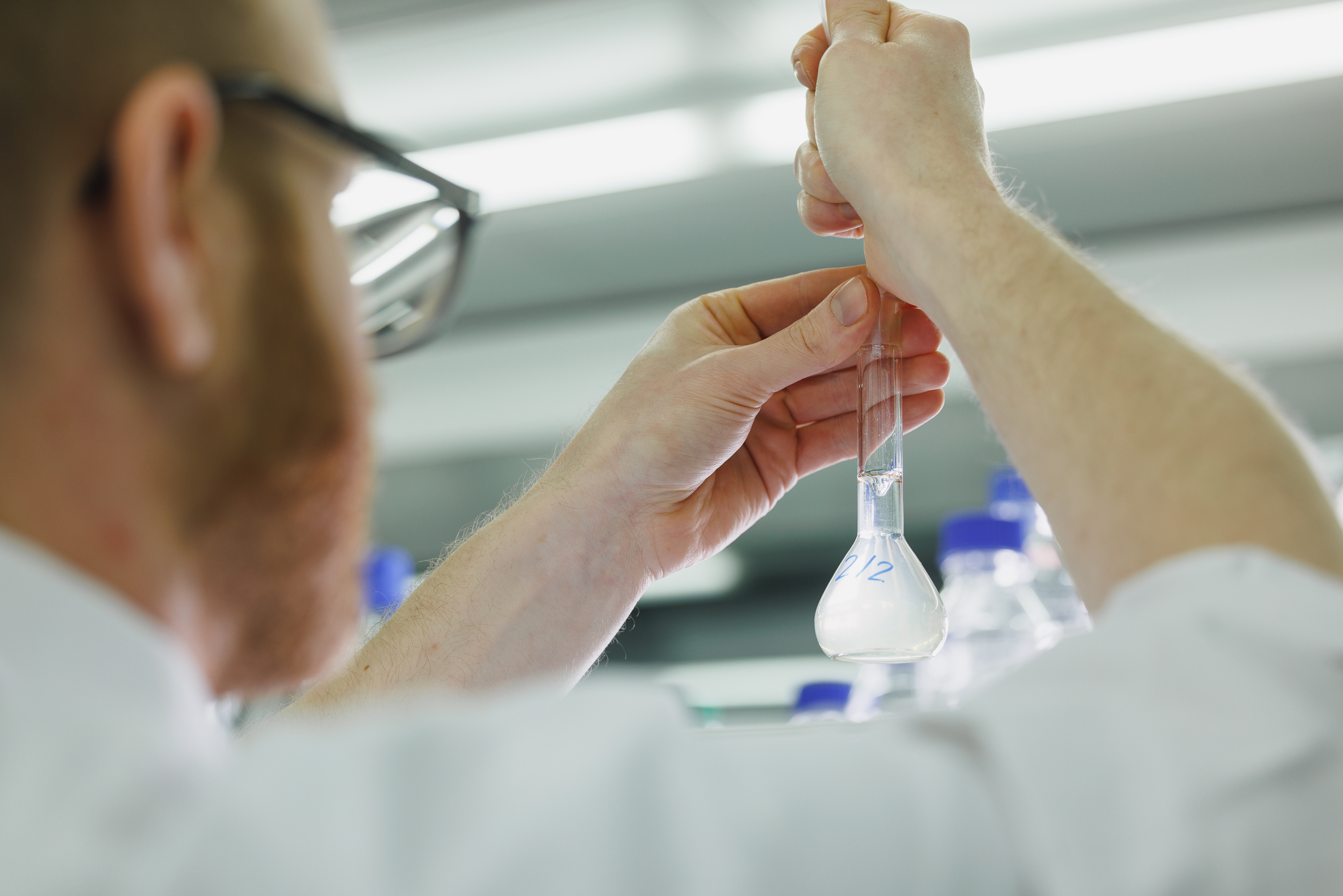 Ein Labormitarbeiter füllt ein Reagenzglas