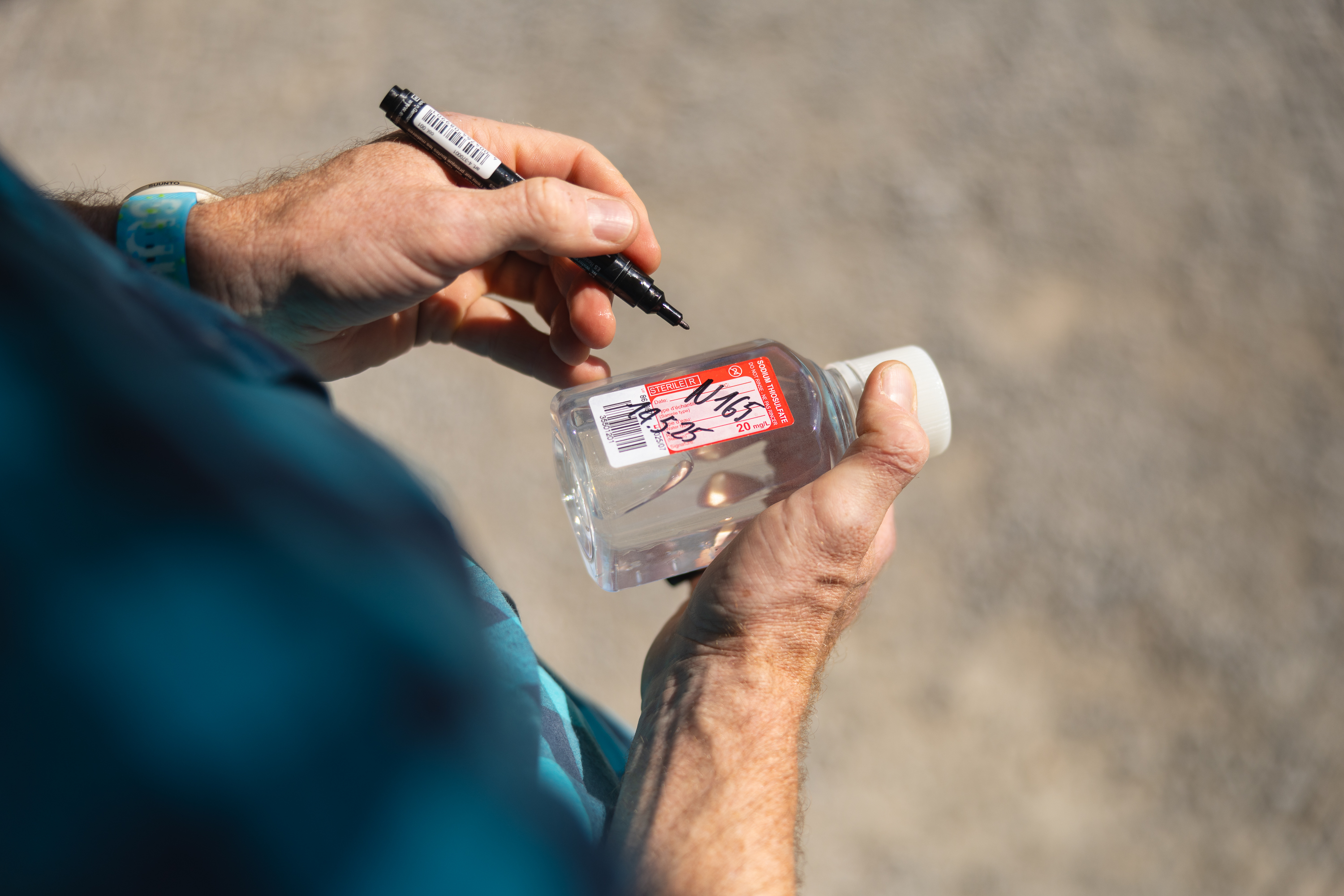 Simon Stüdeli beschriftet eine Wasserprobe mit Datum und Nummer.