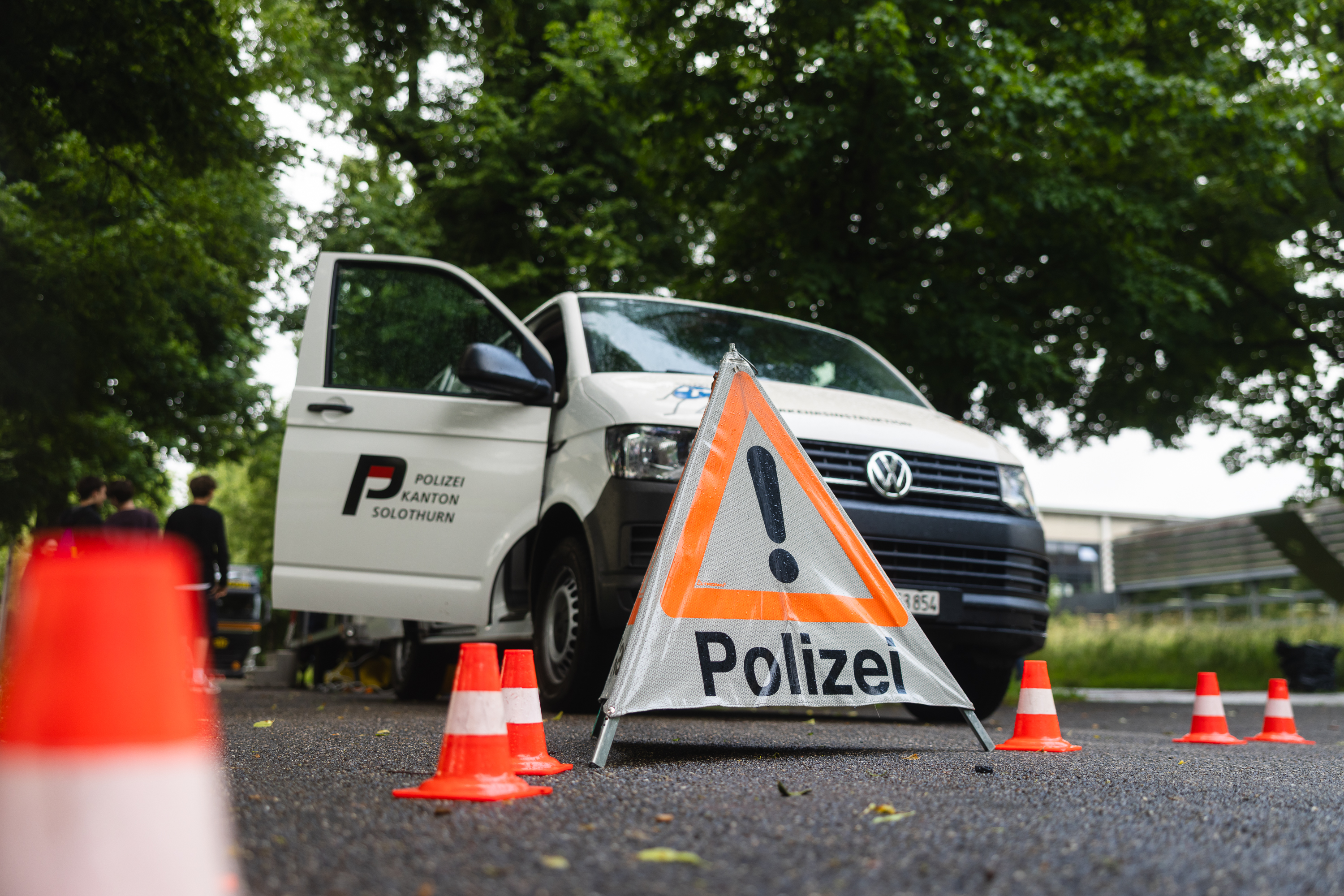 Polizeifahrzeug mit Warndreieck und Pylonen bei Verkehrssicherheitsaktion.