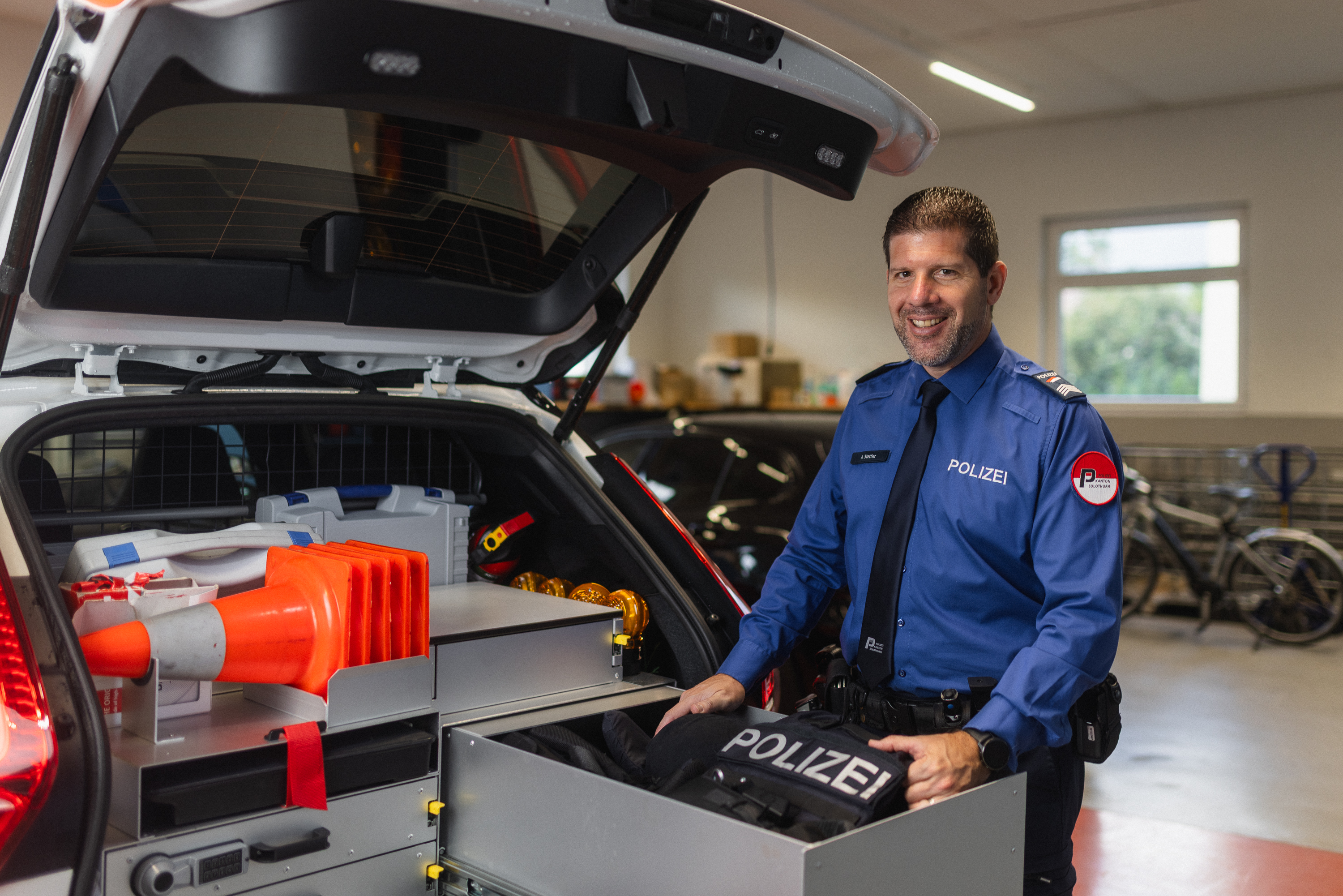 Alexander Stettler räumt den Kofferraum eines Polizeiwagens aus