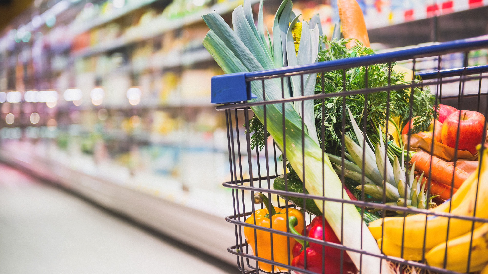 Ein voller Einkaufswagen wird durch einen Geschäft geschoben