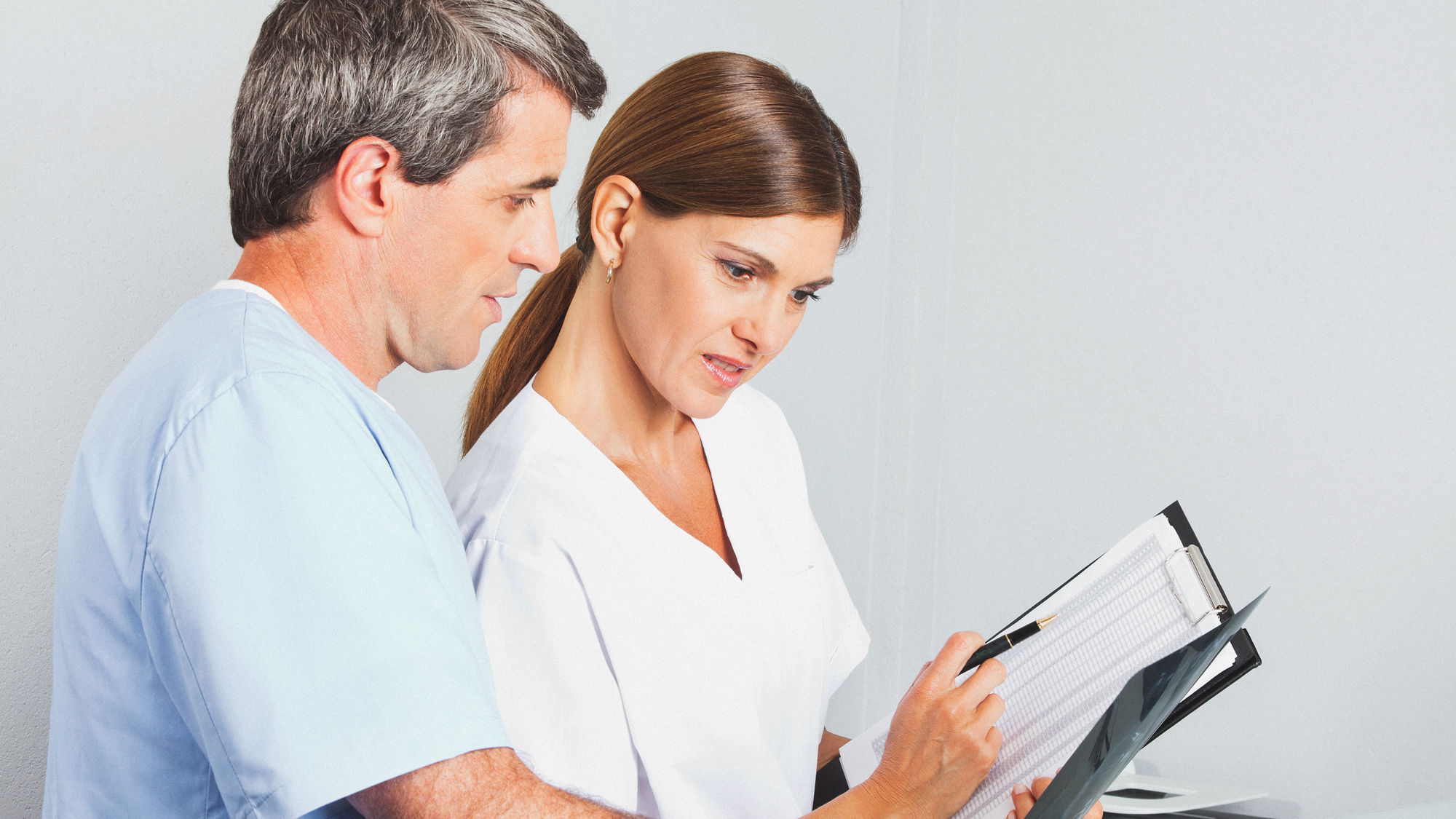 zwei Pflegefachpersonen mit einem Klemmbrett in der Hand