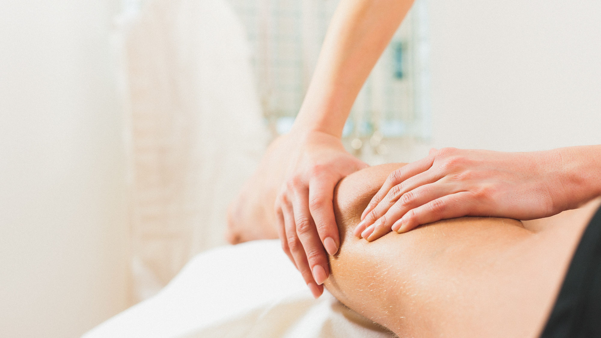 Physiotherapeut behandelt Knie eines Patienten