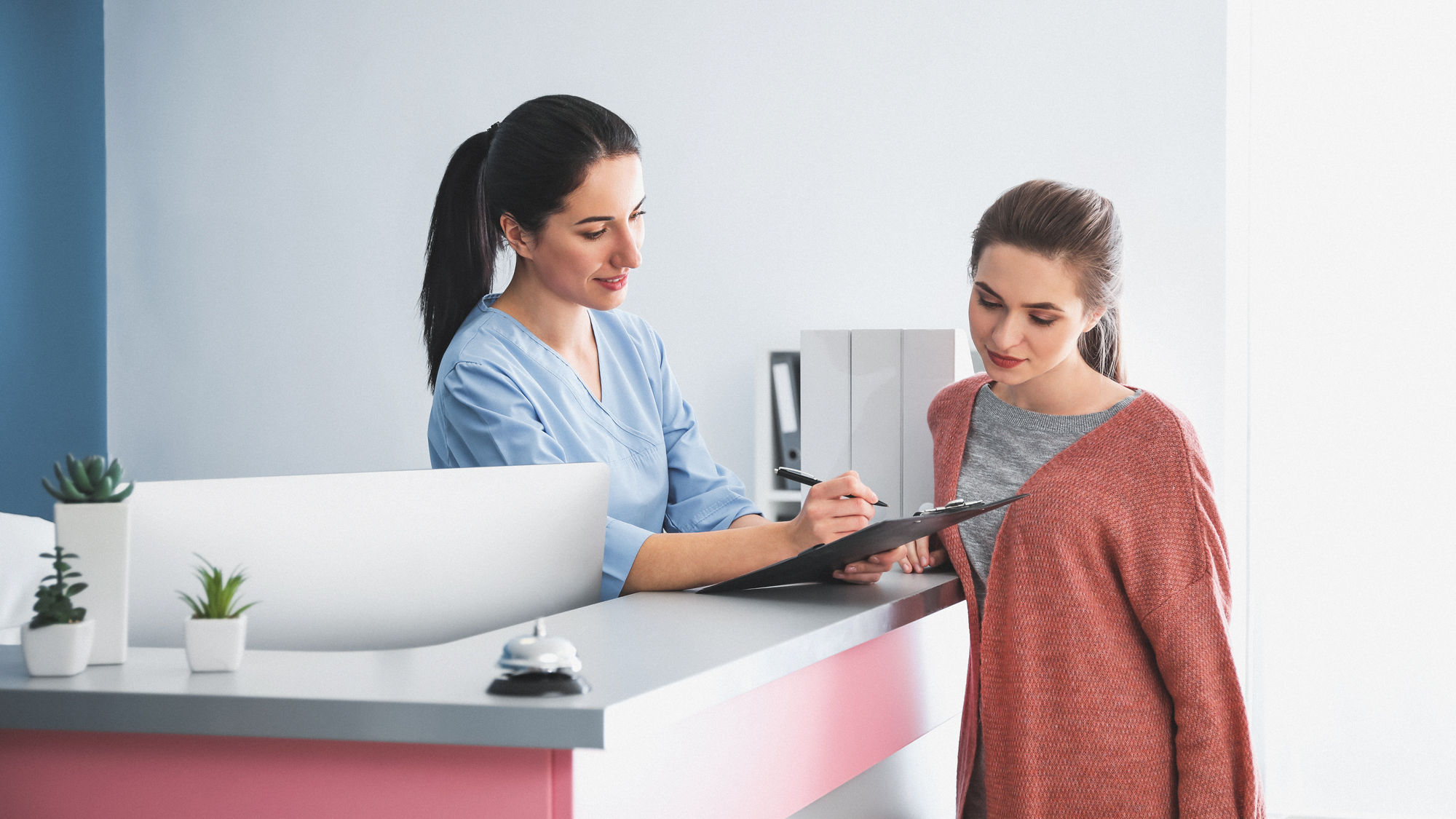 Patientin an der Empfangstheke in einer Praxis