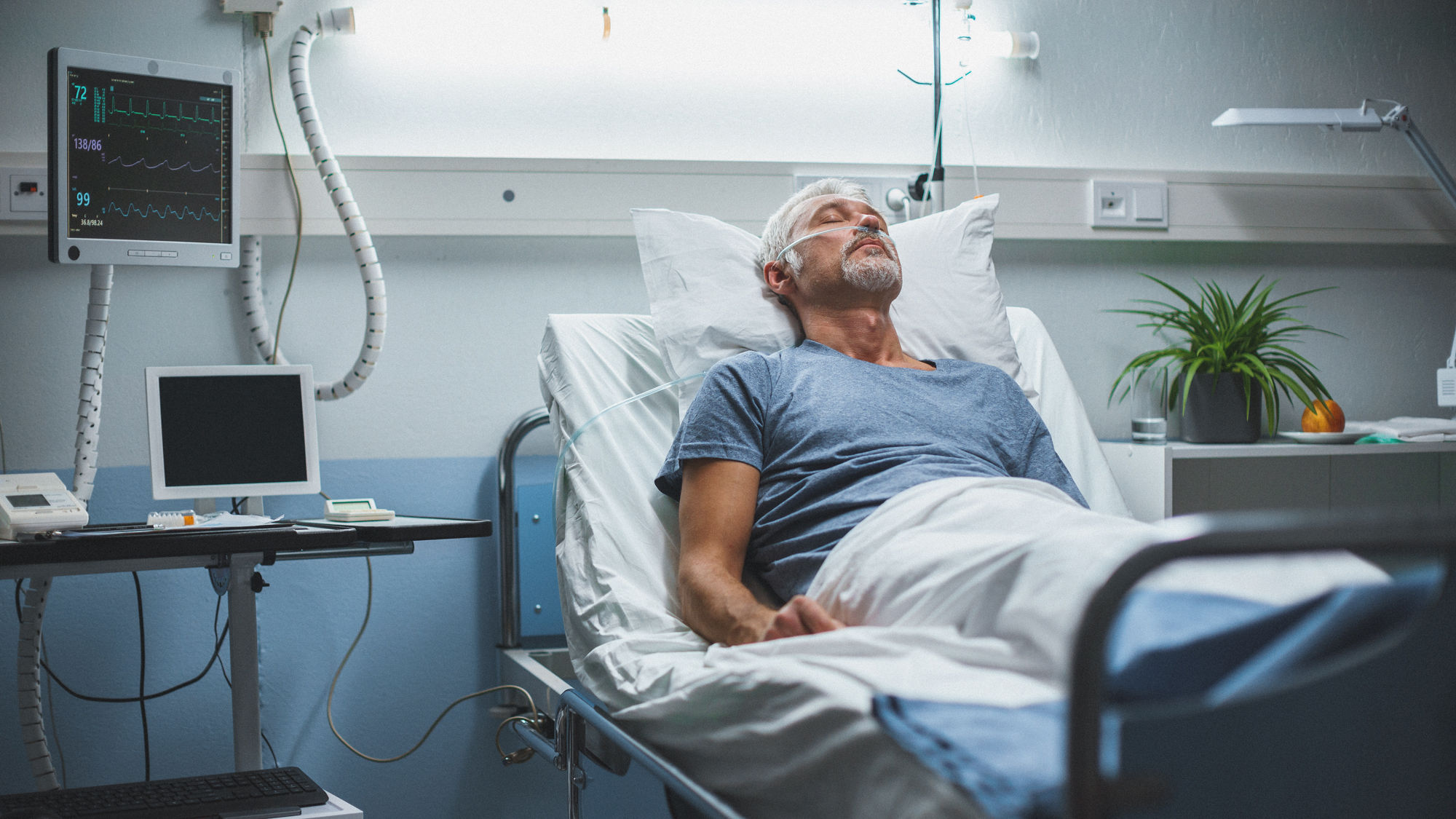 Kranker Mann liegt im Spitalbett