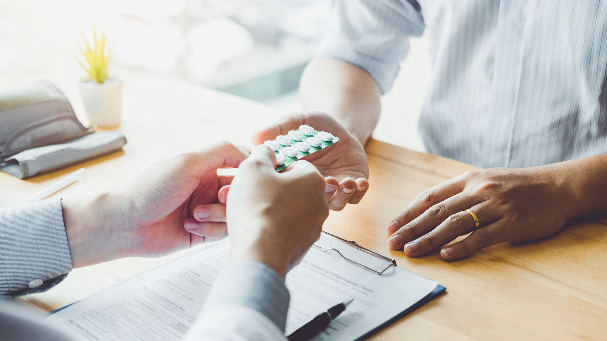 Medizinalperson übergibt Tabletten einem Patienten