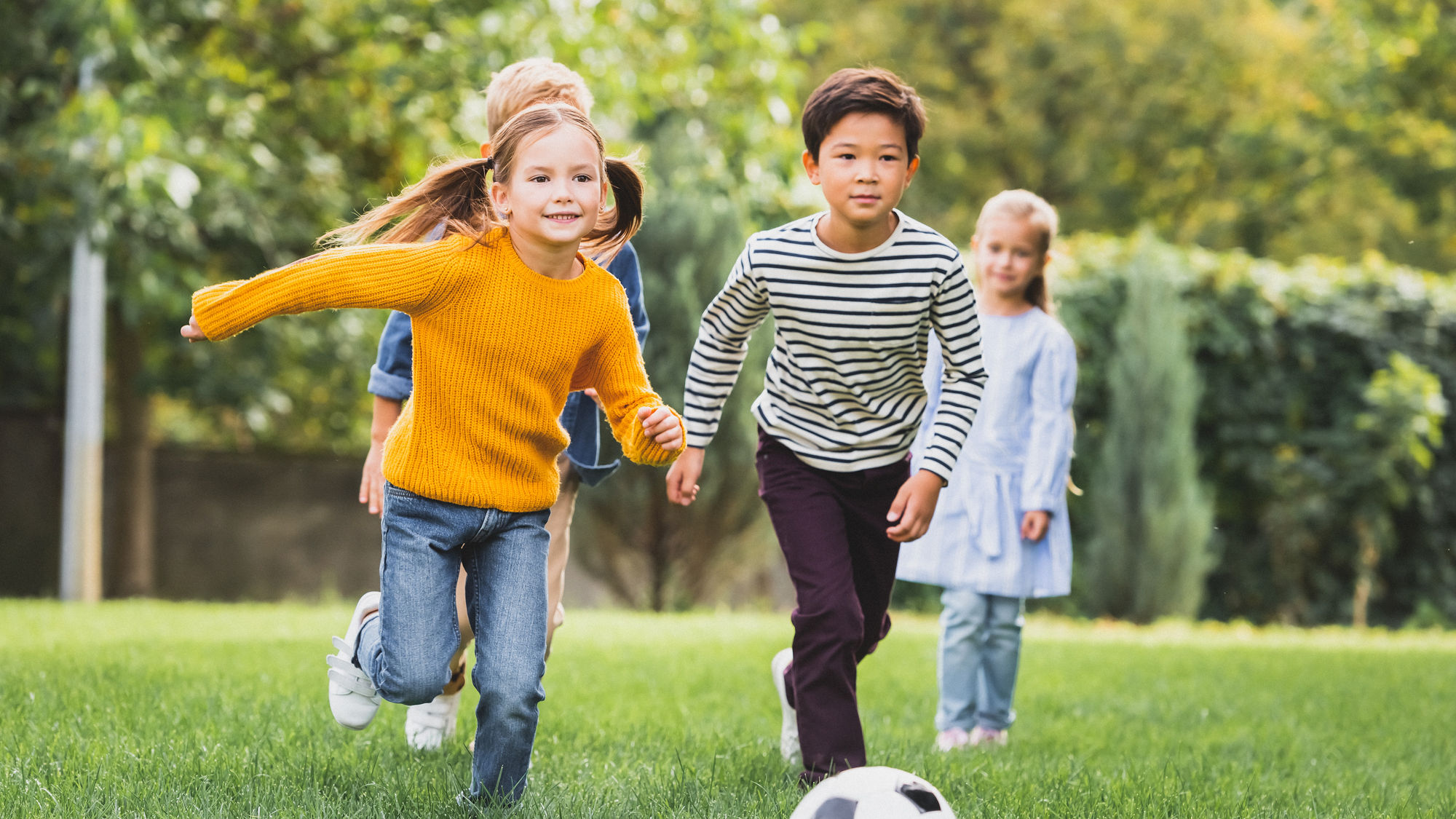 Mädchen und Jungen spielen Ball