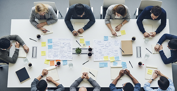 Menschen sitzen an einem Konferenztisch und diskutieren