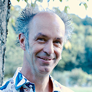 Dieter Sommer Ein Porträt von Dieter Sommer. Er hat seine Haare aufgestellt und grinst in die Kamera.