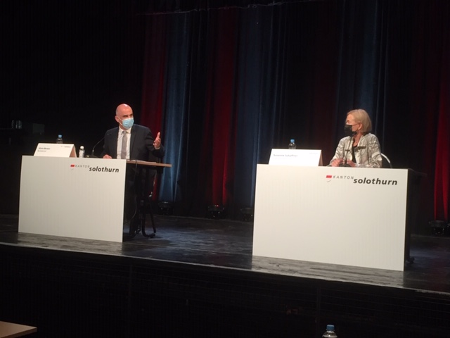 Alain Berset und Susanne Schaffner an der Medienkonferenz auf einer Bühne mit zwei weissen Tischen.