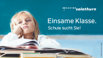 Eine Primarschülerin blickt vor vielen offenen Büchern traurig ins Leere.