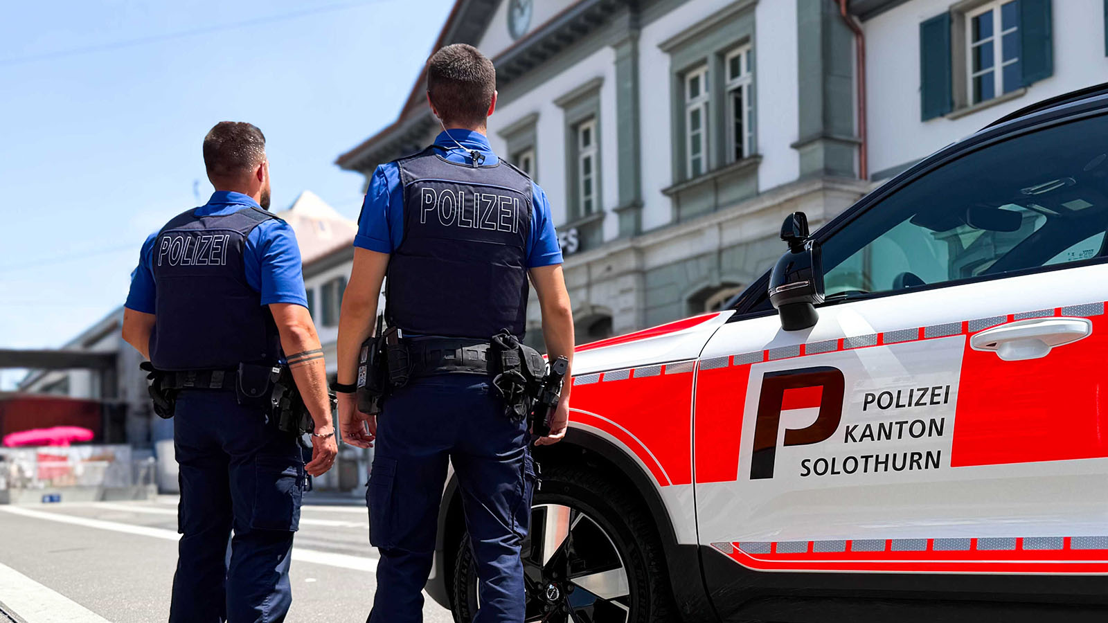 Symbolbild: Zwei Polizisten der Fusspatrouille der Polizei Kanton Solothurn stehen neben ihrem Dienstfahrzeug vor dem Solothurner Hauptbahnhof